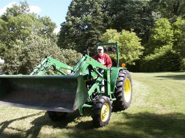 Jim using our neighbor's tractor in the yard