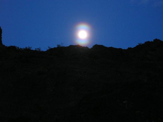 the moon rising over the cliffs