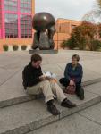 Tom and Anne. Behind them, a sculpture commemorating the first atomic chain reaction and Max P West